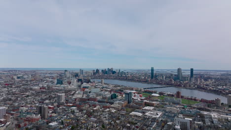 Aerial-panoramic-footage-of-metropolis-at-twilight.-Buildings-in-residential-borough-and-tall-office-towers-in-background.-Boston,-USA