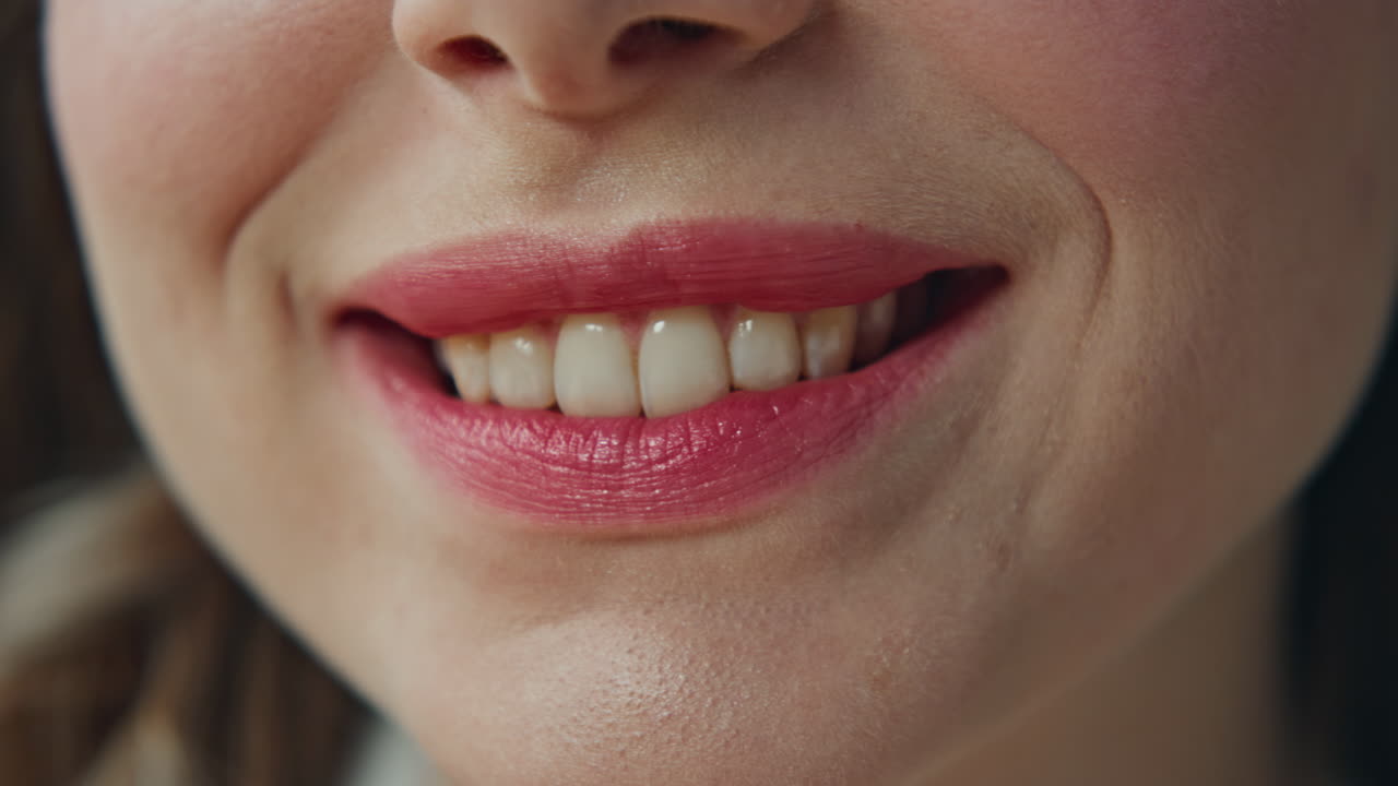 Close-up of a woman's smile with red lipstick