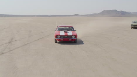 Revealing-shot-of-a-group-of-muscle-cars-coming-together-and-driving-through-the-desert