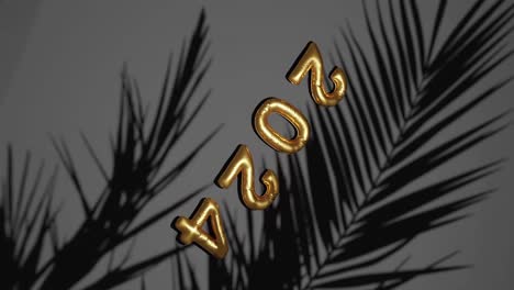Goldener-Ballon-2024-Neujahr-Inmitten-Silhouettierter-Palmen-Vertikal