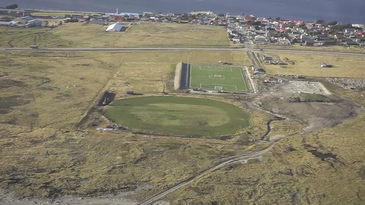 Aerial view of the stanley sports center, featuring cricket and football fields, showcasing the unique sporting landscape of the falkland islands