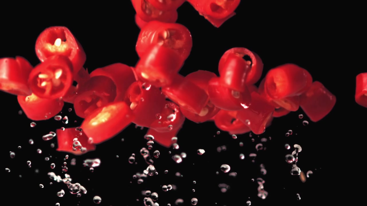 Slow Motion Red Chili Pepper Slices with Water Droplets
