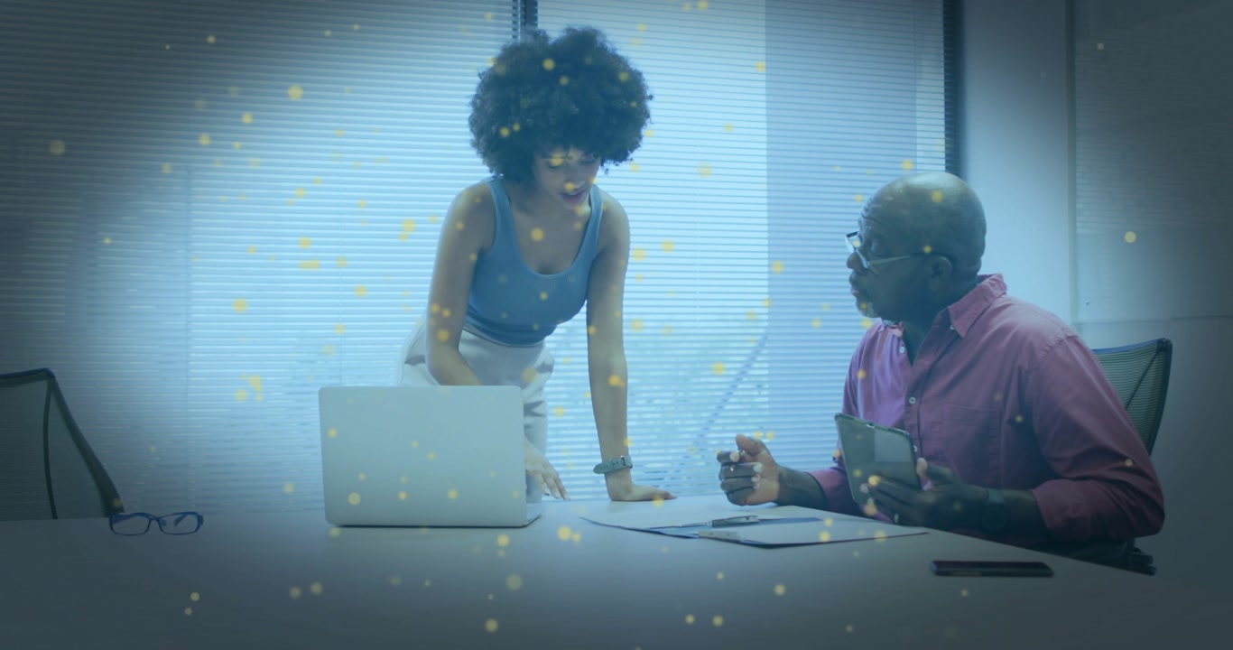 Vertical video: Standing woman leaning on laptop, man holding tablet, discussing business data