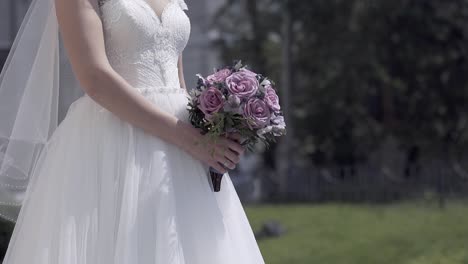 slow motion bride figure in dress with purple bouquet