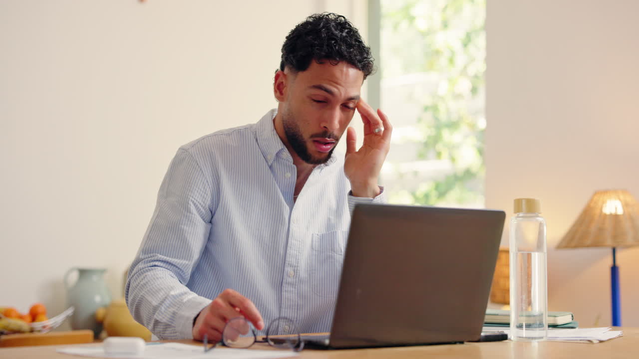 Stressed Man Experiences Eye Strain and Headache While Working on Laptop