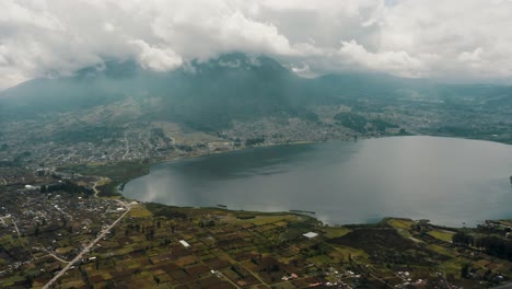 san pablo lake and imbabura volcano on a cloudy day in ecuador - drone shot