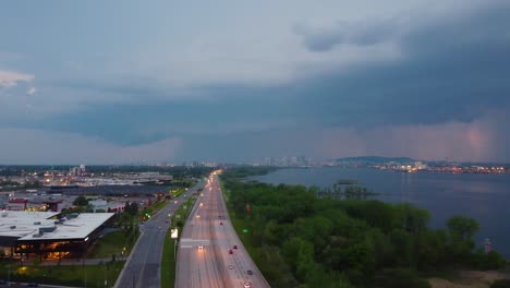 aerial establishing shot of a highway heading to montreal with a lightning storm