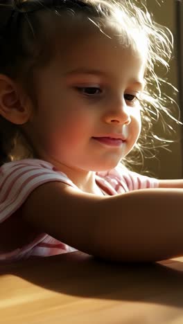 young child assembling wooden puzzle indoor in bright sunlight