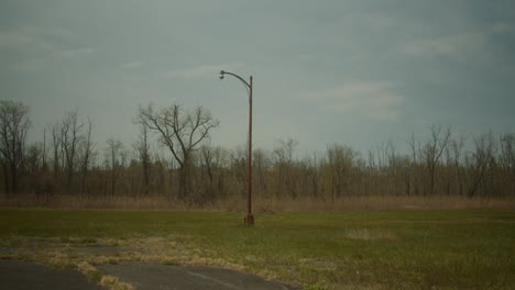 a lonely light pole in the middle of a field