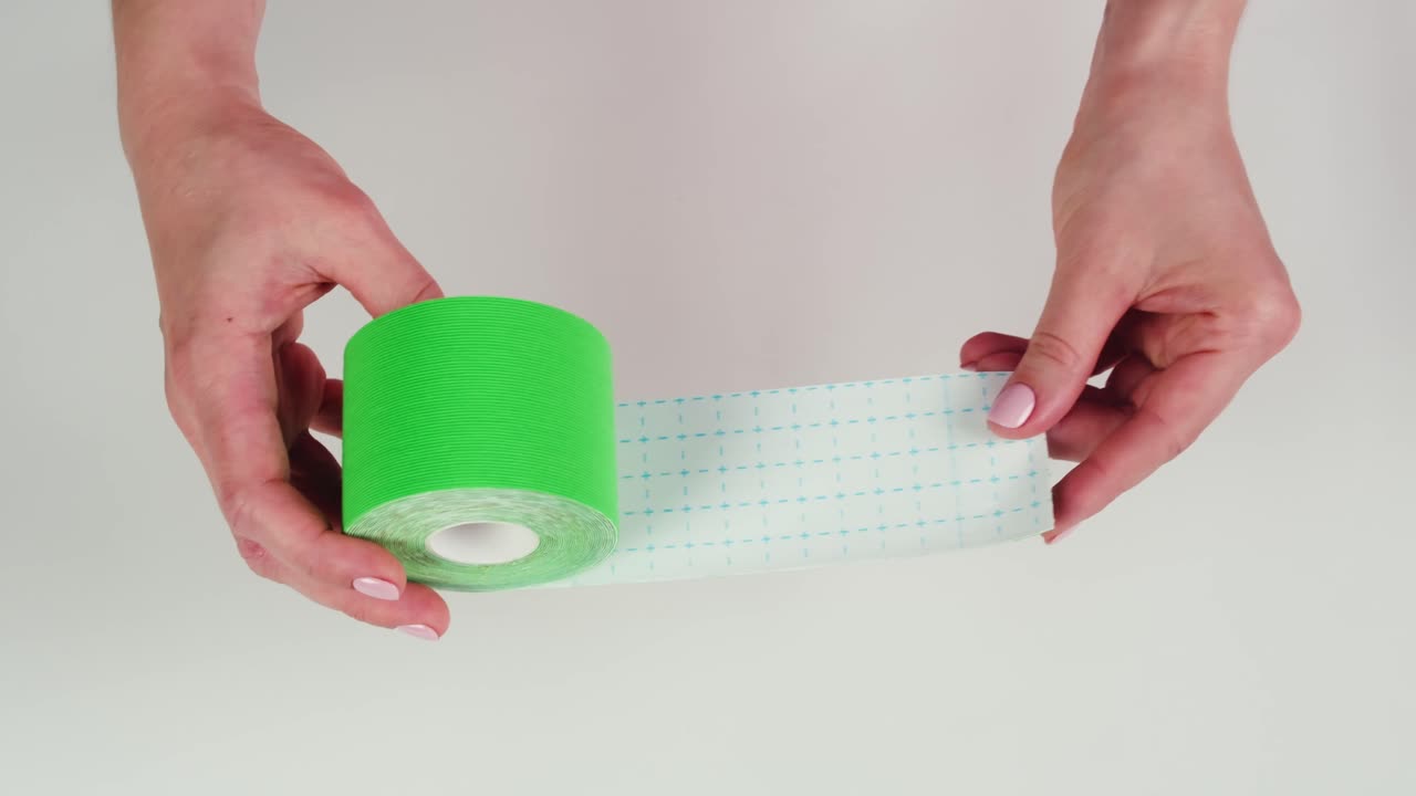 Kinesiology medical taping, doctor Physical therapist applying elastic surgical tape to patient body, treating injured knee young athlete.Post traumatic rehabilitation, sport physical therapy recovery