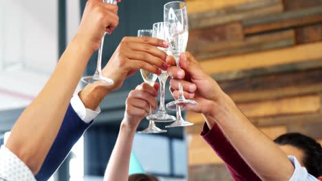 business executive toasting a glasses of champagne in office