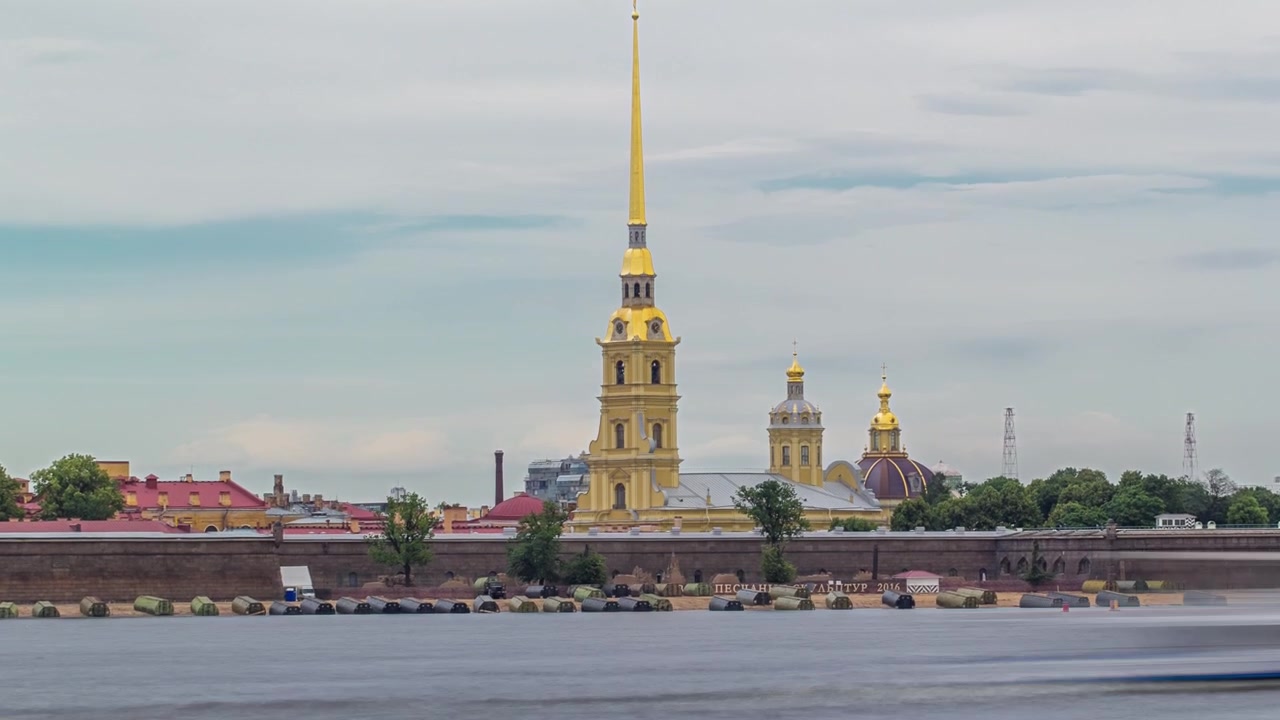 Neva-floden flankeret af Peter og Paul-fæstningen i Sankt Petersborg, Rusland, vist i denne timelapse hyperlapse. Det ikoniske vartegn står højt mod den dramatiske baggrund af en overskyet himmel.