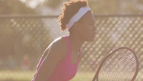 Video-Einer-Fokussierten-Afroamerikanischen-Tennisspielerin,-Die-Einen-Schläger-Hält-Und-Den-Ball-Schlägt