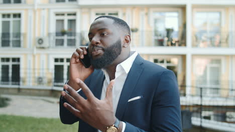 Anxious-african-business-man-having-conversation-on-street.-Man-making-gestures