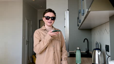 happy blind woman with glasses talking on mobile phone at home