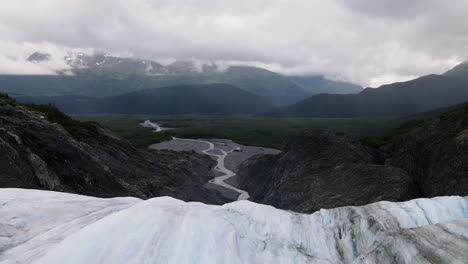 Aerial-view-down-from-a-glacier-in-the-Tongass-national-forest,-in-cloudy-Alaska