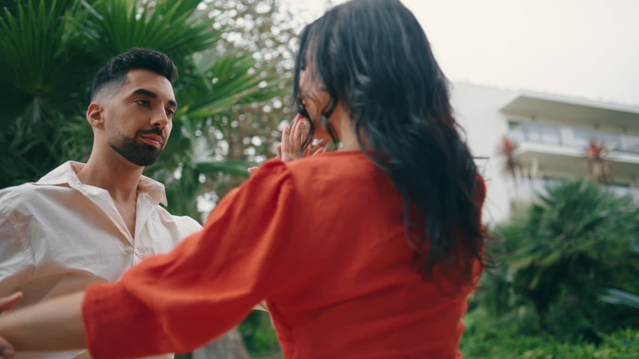 bailarines enérgicos moviéndose apasionados realizando salsa en el parque de la ciudad verde de cerca