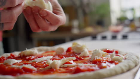 putting ripped mozzarella on top of pizza