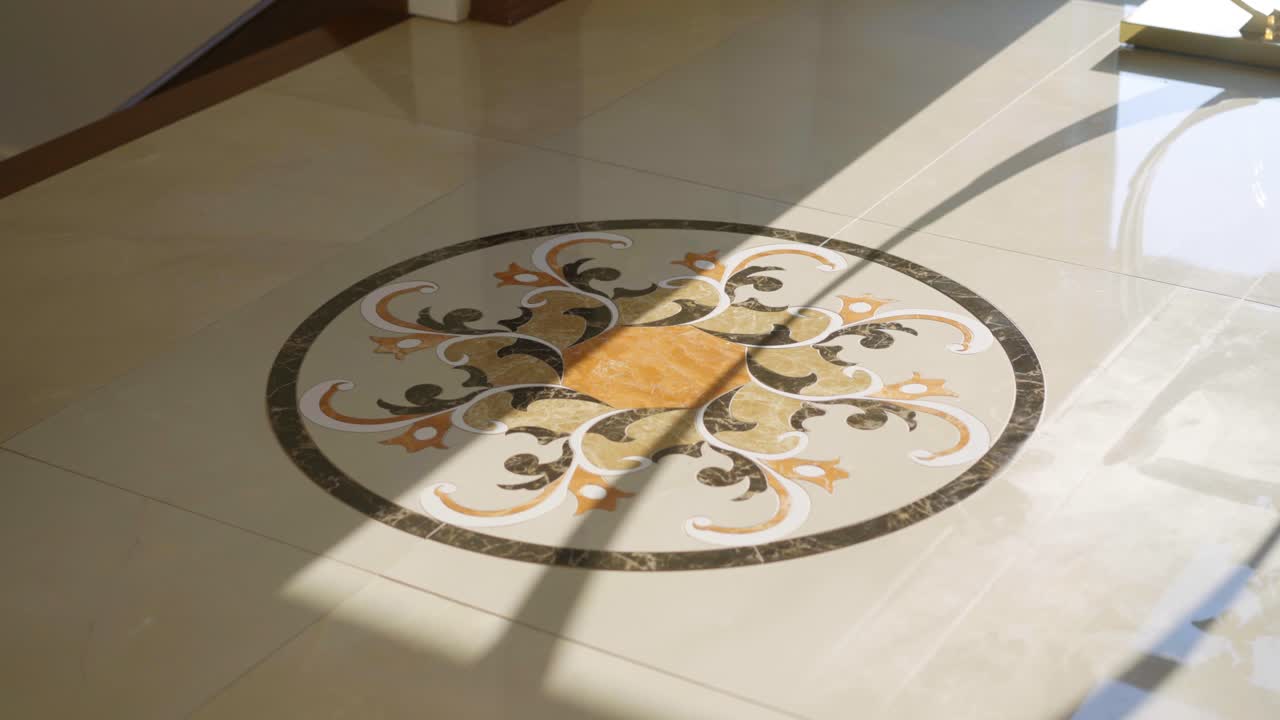 Una toma cinematográfica del elegante suelo de baldosas de mármol en una casa de lujo con preciosas obras de arte en las baldosas.