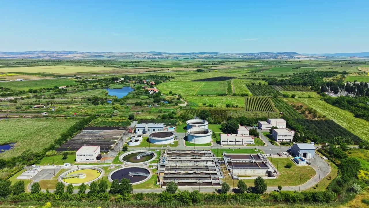 Wastewater treatment facility in operation with large tanks and equipment in view during daylight hours