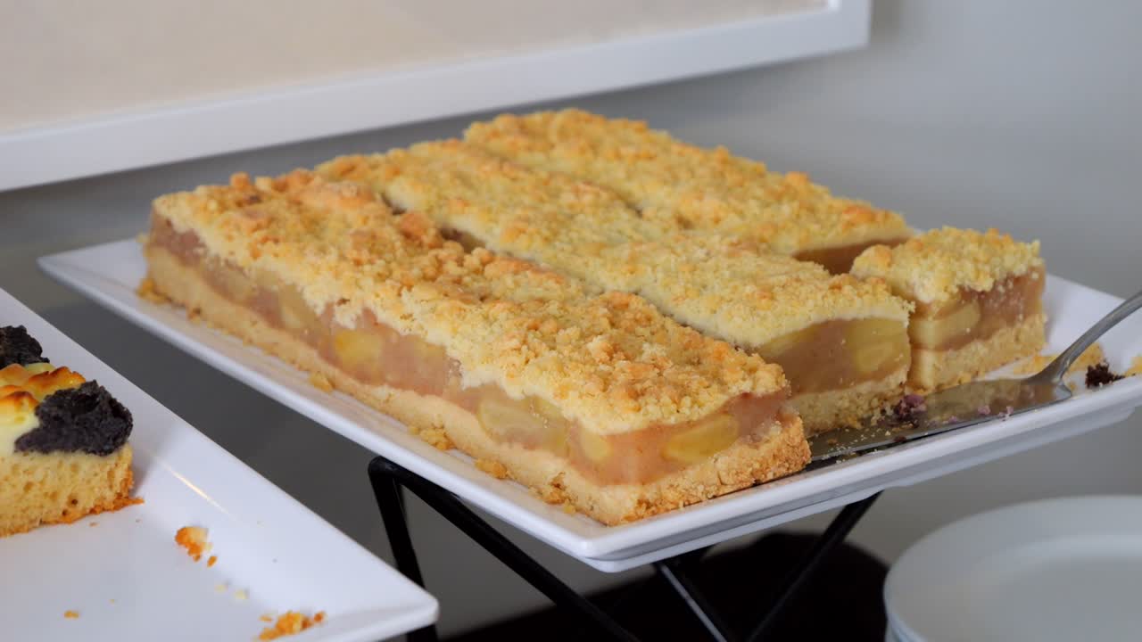 pastel de manzana, un pastel con relleno de manzana cortado en pedazos y dispuesto en una mesa con golosinas dulces.