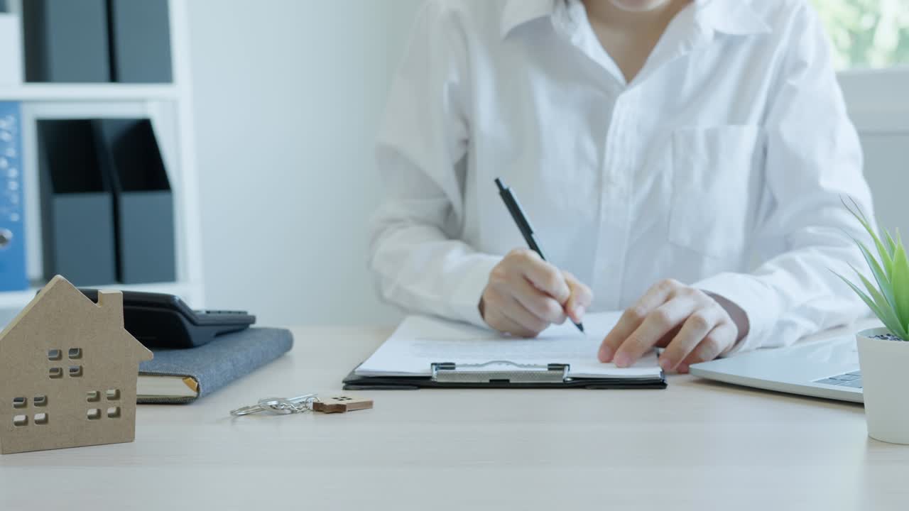 corredor de seguros de vivienda o vendedor que tiene una llave de la casa dada a un nuevo propietario. la agencia revisa los detalles del documento antes de firmar el contrato. venta de casas, bienes raíces y concepto de propiedad.