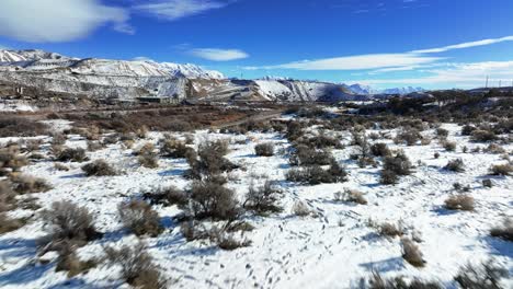 beautiful aerial view of snowy mountains and bushes in bluffdale utah - forward reveal