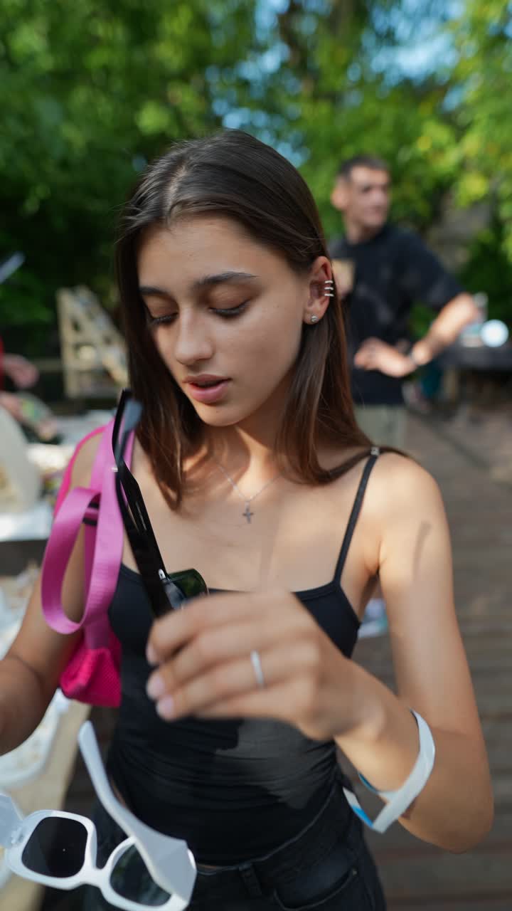 joven comprando gafas de sol en un mercado de verano
