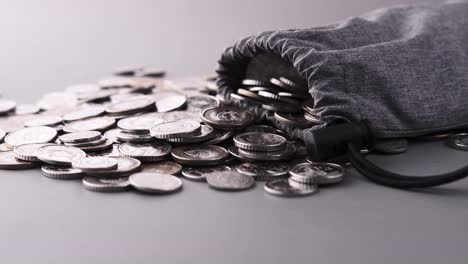 un montón de monedas en una bolsa gris