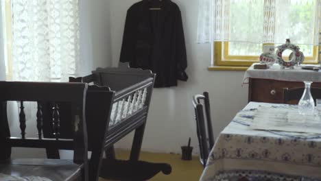 antique bench, cradle and table inside historical vintage bedroom of old house