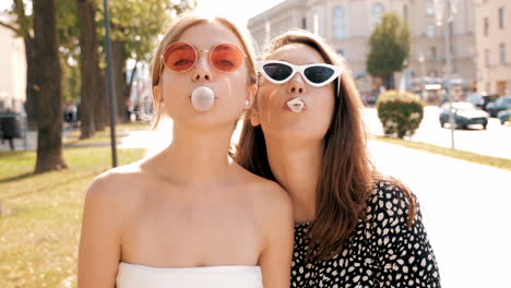 two friends blowing bubbles in a city park