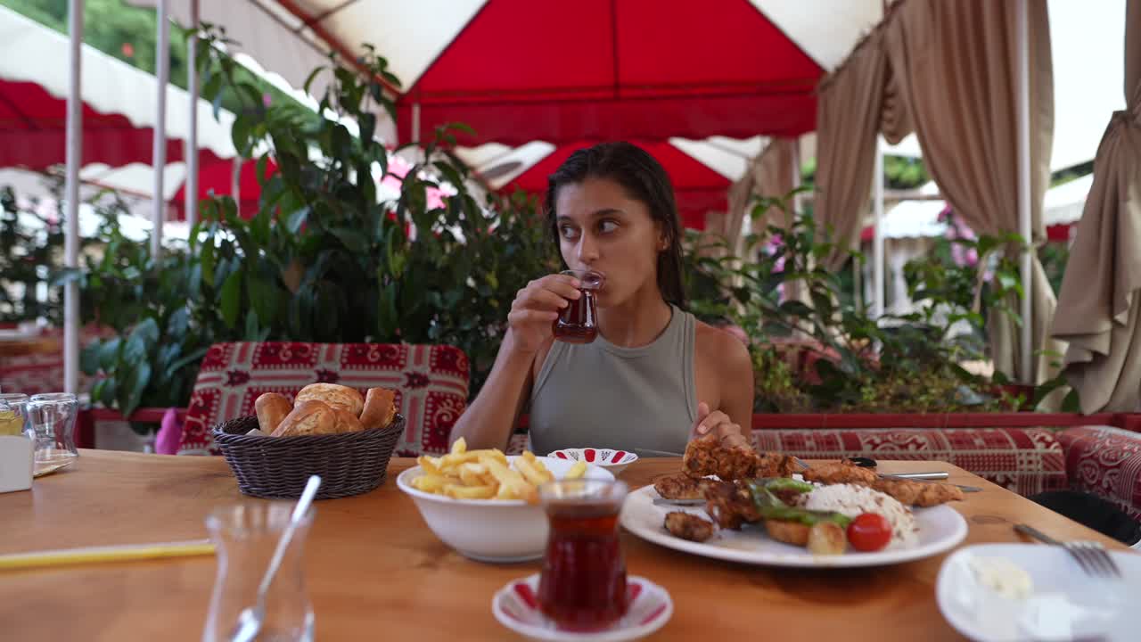 Woman enjoying a meal and tea at a Turkish restaurant