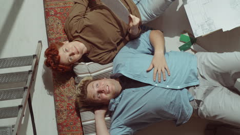 Couple-Lying-on-Floor-and-Smiling-at-Camera