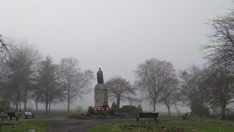 world war cenotaph in park surrounded by misty fog and spaced out trees uk 4k