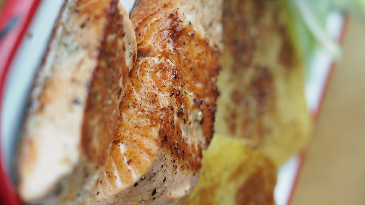 Primo piano di filetti di salmone cotti con patate arrosto