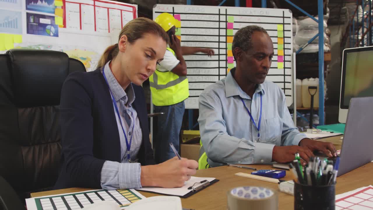 personal trabajando en un escritorio en un almacén 4k