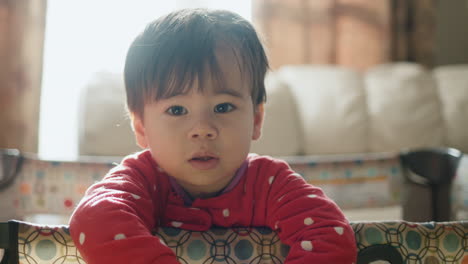 slightly sleepy asian baby standing in his crib