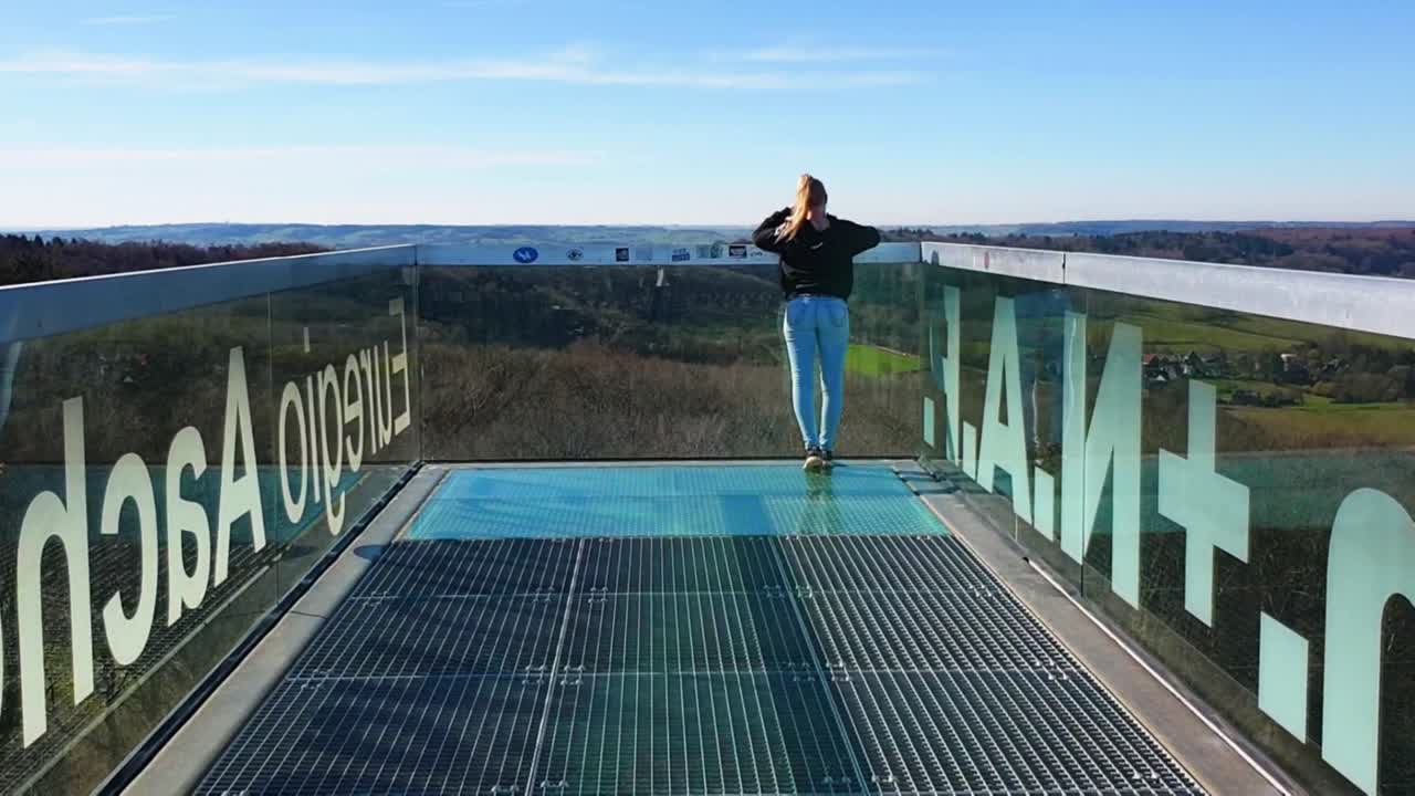 금발 소녀가 파노라마 데크의 전망을 즐기고 있습니다 - 맑고 화창한 날