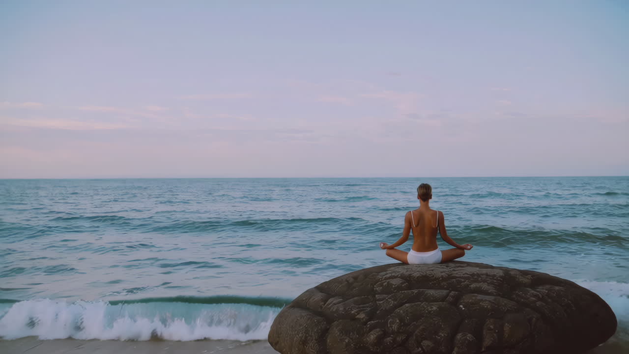 mujer meditando en una roca junto al océano