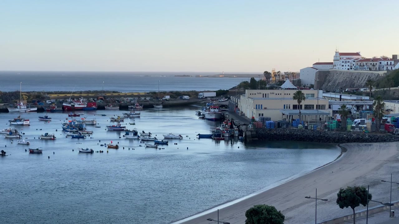 Barche da pesca ormeggiate in un porto tranquillo, che riflettono la vita costiera e l'attività marittima in un'incantevole città portoghese.