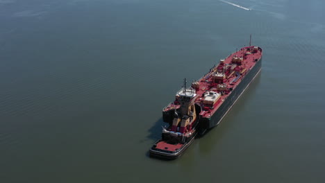 a drone view of a large red barge on the hudson river in ny