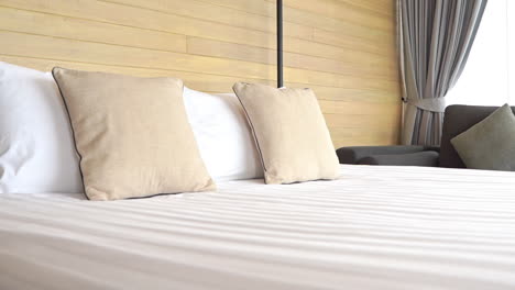 pan a lo largo del lado de una cama de hotel bien equipada
