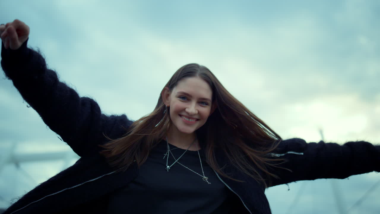 chica dando la vuelta en la calle urbana. mujer sonriente en primer plano levantando las manos