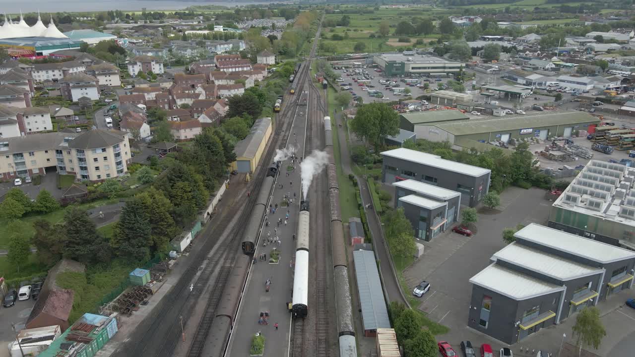 Aerial view of the Minehead steam railway station England's longest heritage line, running 20 miles between Minehead and Bishops Lydeard. Drone slowly moving forward over two steam trains