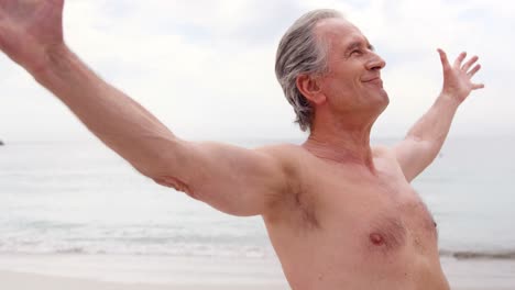 Retired-man-outstretching-arms-on-the-beach