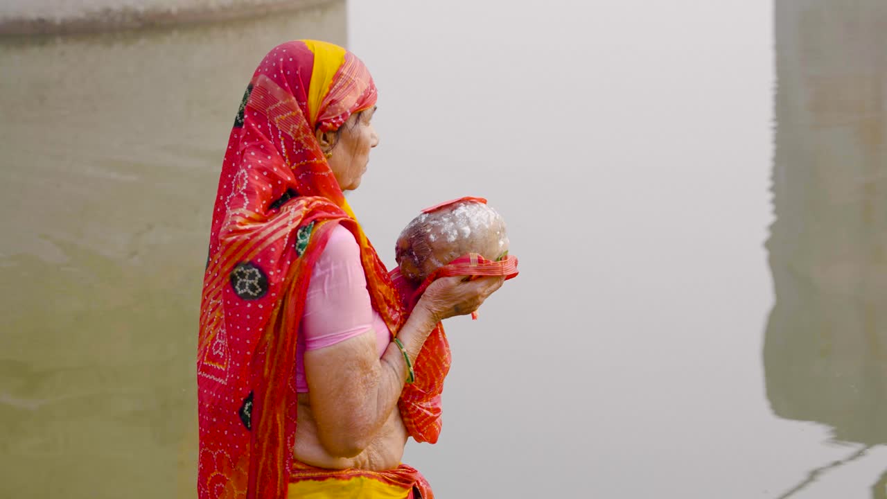 mujer anciana india orando al sol