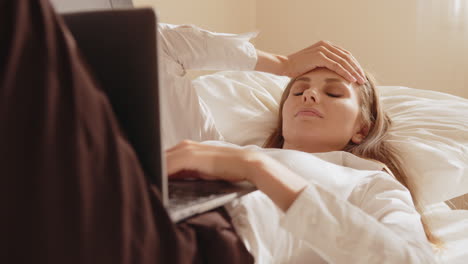 woman working on laptop in bed