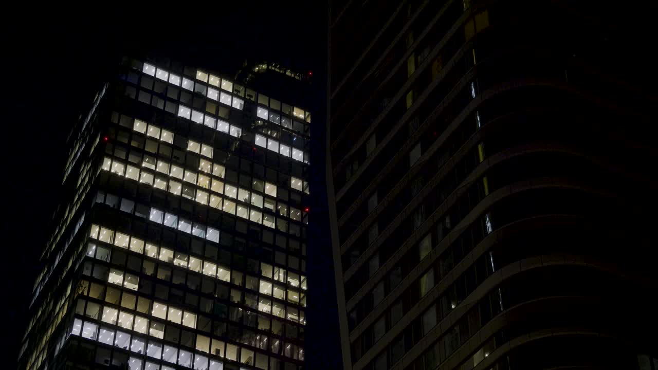 View of illuminated office windows in Frankfurt skyscrapers at night with a modern feel