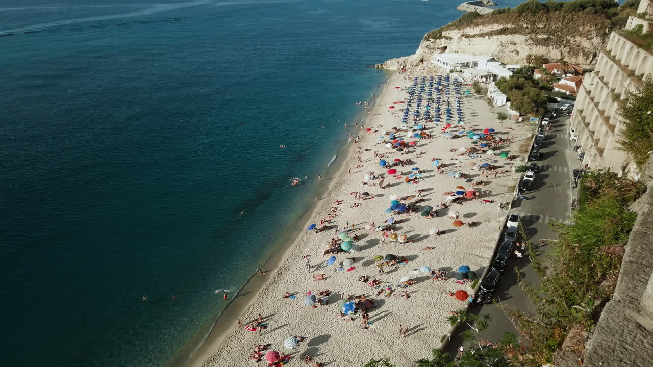 побережье полно туристов и зонтиков.