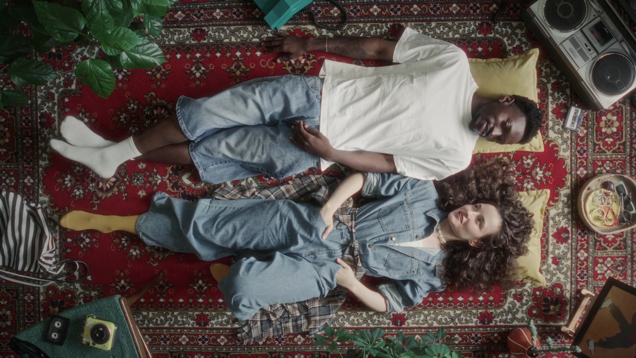 Directly Above of Couple Chatting and Smiling while Relaxing on Vintage Rug